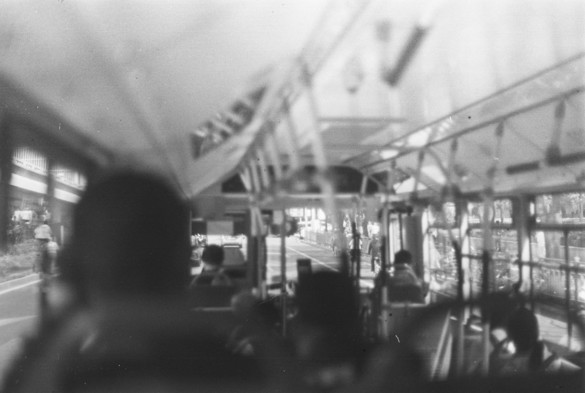 The black and white image of the inside of a bus and its passengers