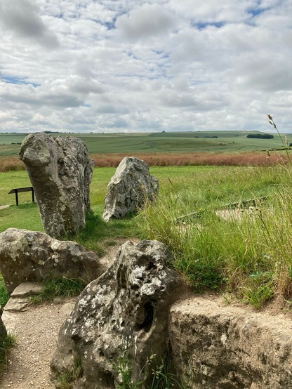 Ancient burial chamber near Avebury in Wiltshire, photo taken from the roof of the chamber with fields in the background and stones at the entrance 