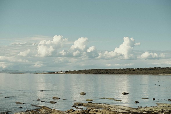 A colour photo of a very calm and sunny Firth Of Forth, looking from Longniddry over Gosford Bay and across to Fife in the distance.  Scotland.

Photo by and copyright of Paul Henni.