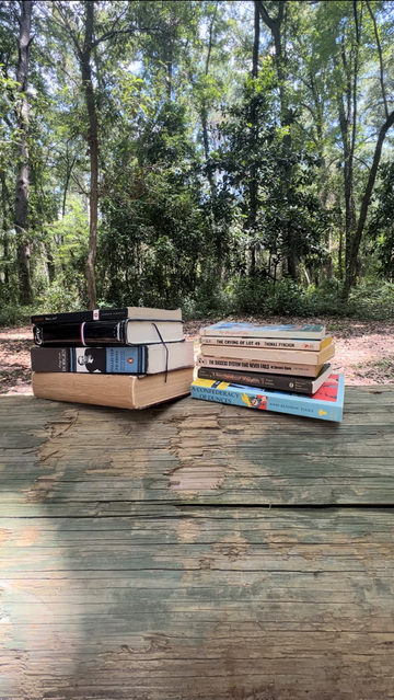 Two stacks of books rest on a log.