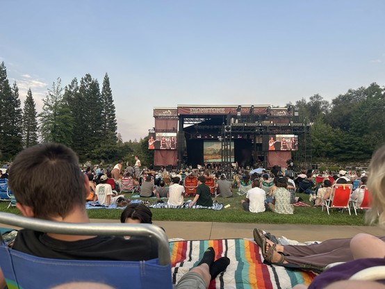 Sunset comes to the ironstone winery amphitheater as Y La Bamba opens their set. The view of the band is hard to see through the sound board setup to the right, but the large displays on the left and right show the same view of band members enlarged for the lawn audience .