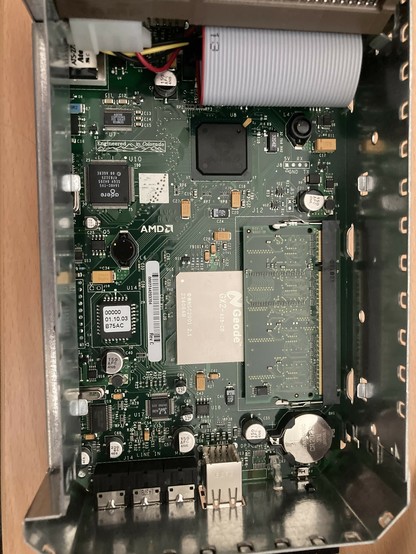 A printed circuit board. We see a Geode GX2 processor partially covered by a stick of RAM, an Agere 1648C-TV5 modem, the BIOS chip, the Realtek ALC203 audio codec and the chipset, though its markings are unreadable in the photo.