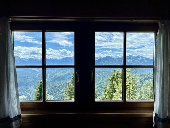 Blick von innen aus einem Fenster auf ein bergpanorama. 