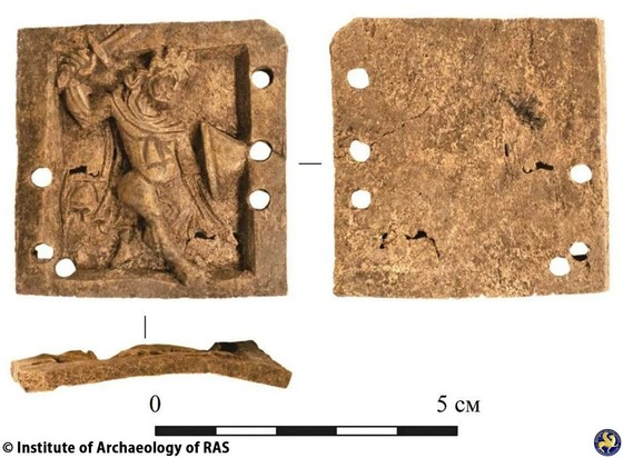 Byzantine bone plaque discovered in Suzdal

Archaeologists have unearthed a rare Byzantine bone plaque within the historic walls of Suzdal, Russia. This intricately carved artifact, measuring 45 x 46 mm, features a detailed depiction of a semi-naked warrior wielding a sword and shield, crafted with fine facial features and flowing hair. The plaque includes six asymmetrical mounting holes around its raised exterior border.

This find, believed to be a decorative overlay from a casket, dates back to the 10th to 12th centuries. These caskets, often produced by artisans in Chersonesus or Constantinople, were typically made of wood and adorned with small bone plaques attached using bone nails or pins.