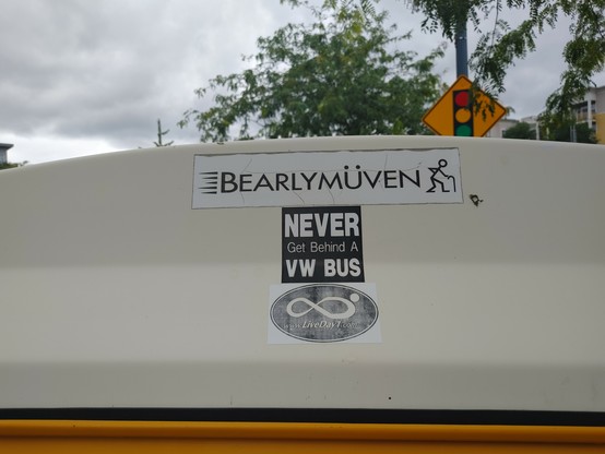 Stickers on VW Microbus: 

Barelymuvin in faux German. 
”Do not get behind a VW Bus
