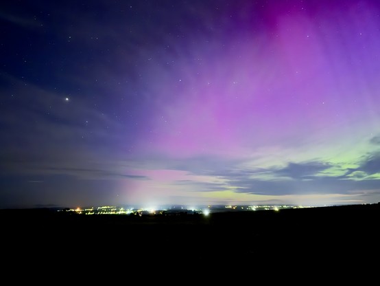 The Aurora with city lights in the background. 