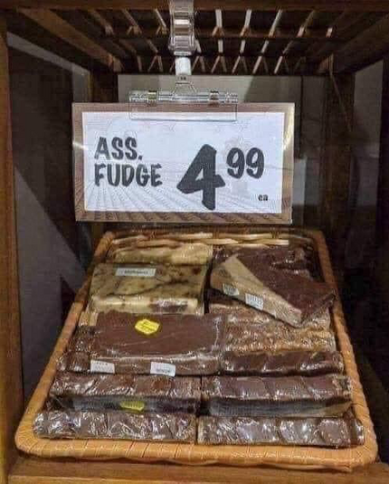 Store display of assorted kinds of fudge and a sign that says ASS. FUDGE