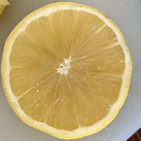 A close-up of a halved lemon showing its juicy interior.