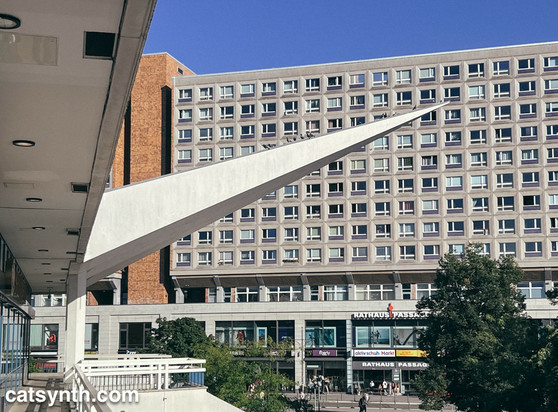 Pointed overhang of brutalist pedestrian walkway in front of brutalist hotel building in Alexanderplatz, Berklin.