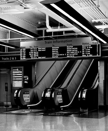 Black and white photo of the lobby of the Joseph R. Biden, Jr. Train Station in Wilmington, Delaware. Pres. Biden, a long-time resident of Wilmington, commuted by train between Wilmington and Washington, DC as a Congressional representative and senator over many years. His enthusiastic advocacy in support of Amtrak led to the station being named after him. 