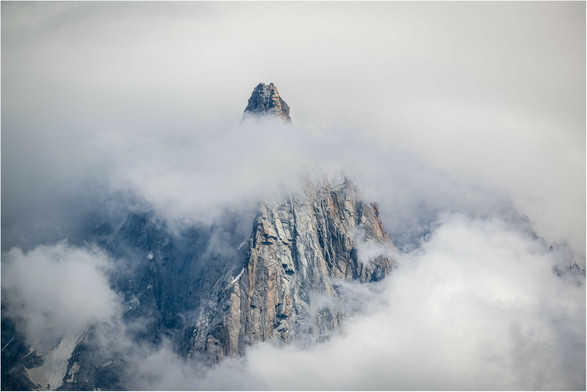 Conical peak of the Dru emerging from the clearing storm clouds.