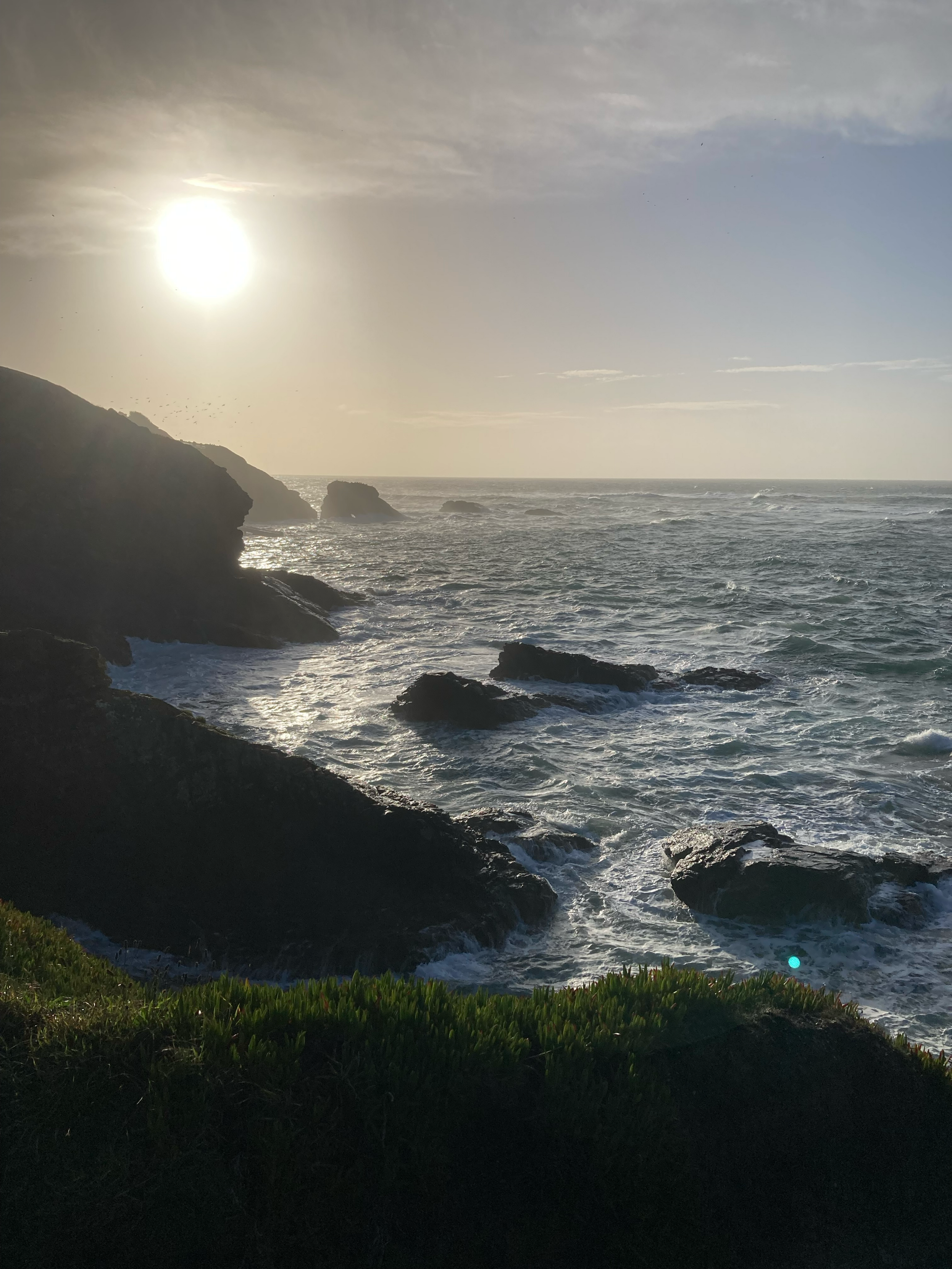 The sun rising over the sea and Cornish cliffs