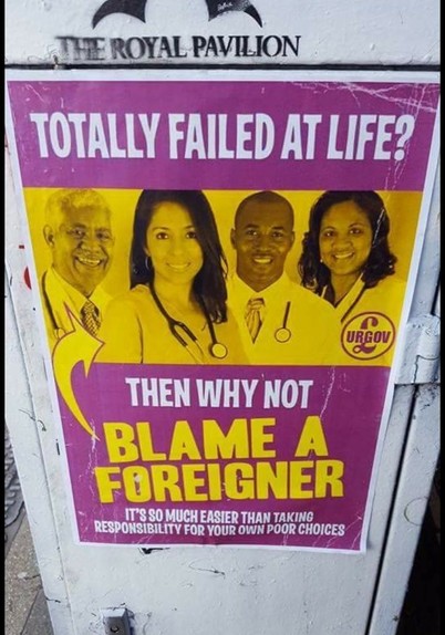 Poster on a street corner displaying some nicely dressed non-Caucasian professionals.  Captioned, "Totally failed at life? Then why not blame a foreigner.  It's so much easier than taking responsibility for your own actions."
