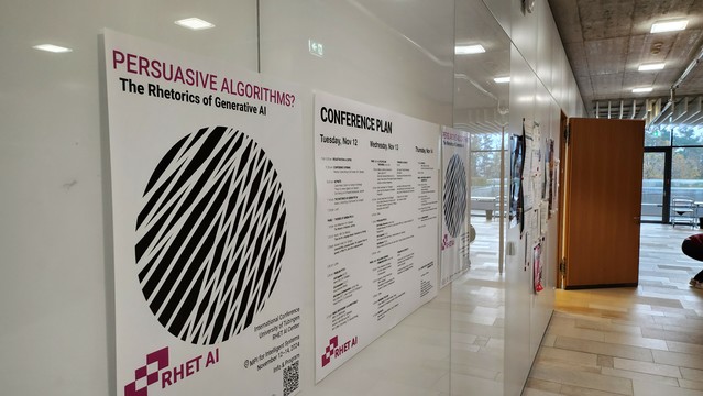 The picture shows the conference poster for the Persuasive Algorithms conference and the conference plan put up in the MPI-IS outside of the main lecture hall.