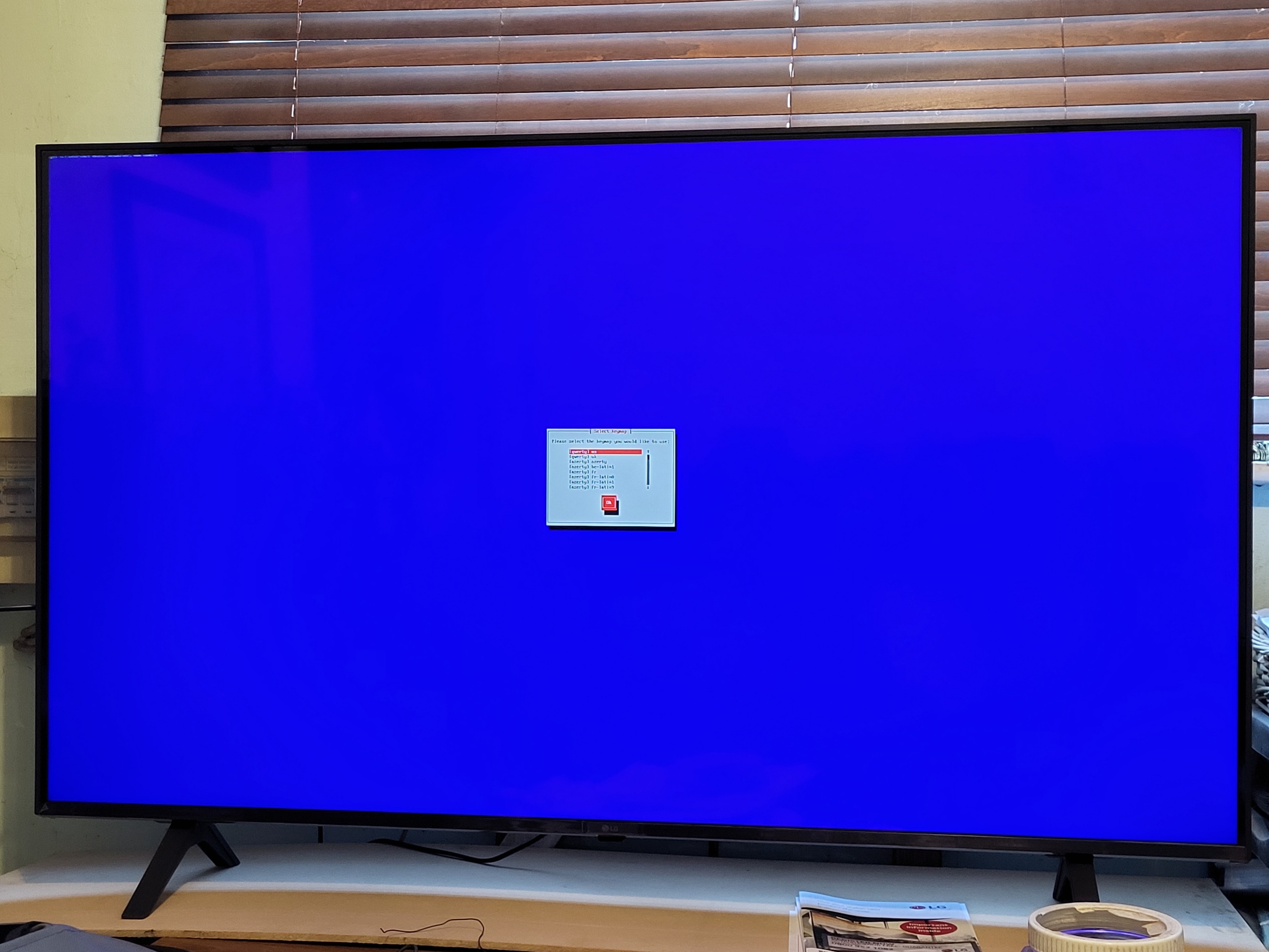 TV displaying a blue background. In the centre is a very small txt set up box. Text too small to read.