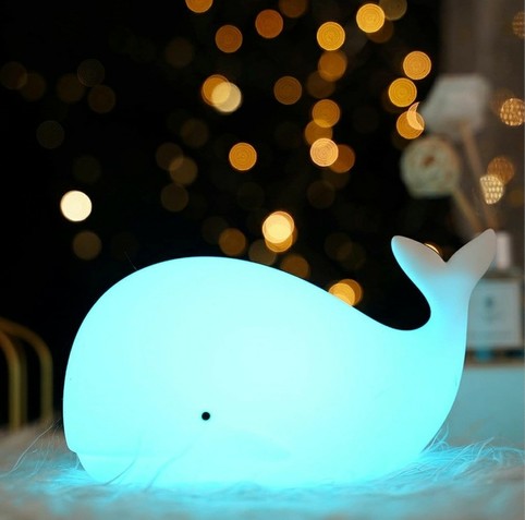 A blue whale lamp that is all lit up.