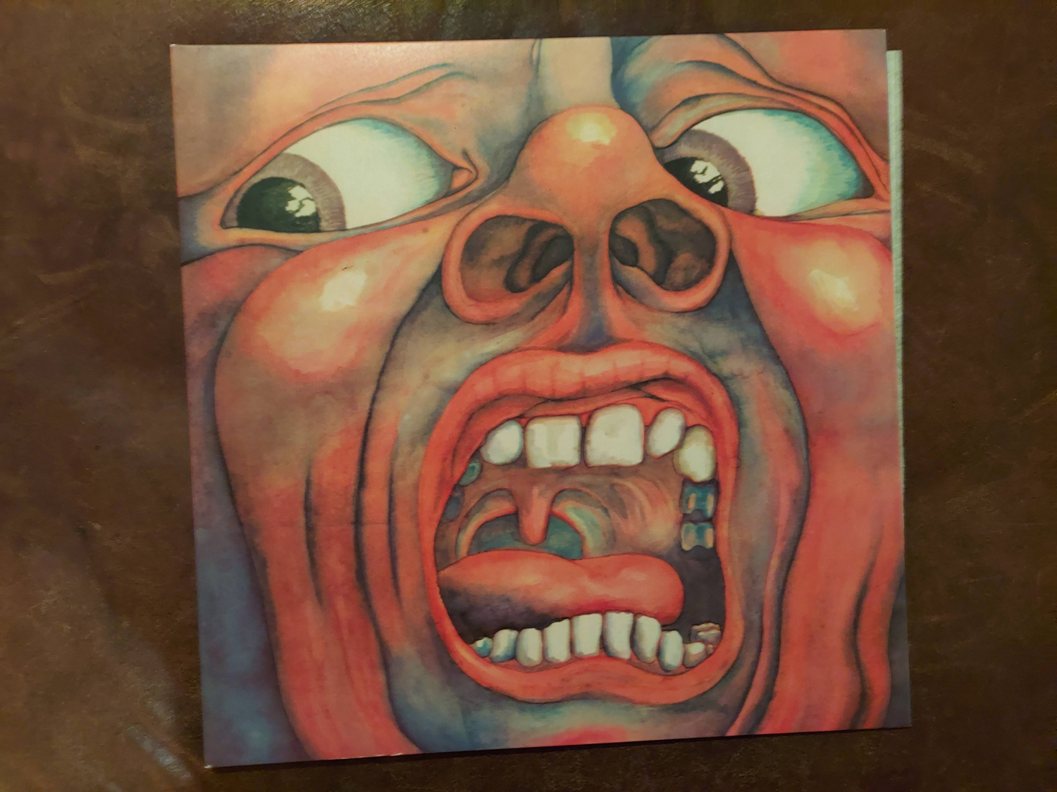 Cover of the album "In the Court of the Crimson King," with a mostly red image depicting a large, distorted mostly red face screaming with bulging eyes.