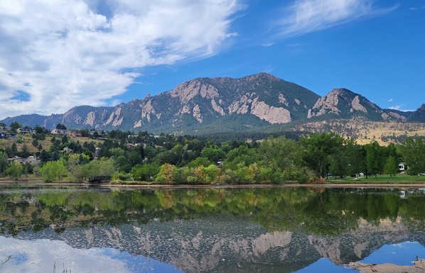 Mountain landscape reflected in water under blue skies 