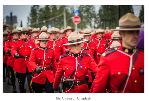 Photo of Canadian Mounties in red uniforms marching 