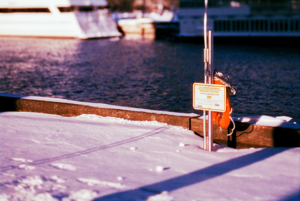 An emergency station at the edge of a snow covered pier. 