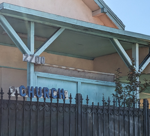 Wood block sign over a fence: Church