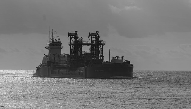 Black and white photo of a LNG ship coming in to port