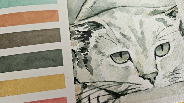 Paper with a cat painting that rests its head on a paw and looks almost a little sad.