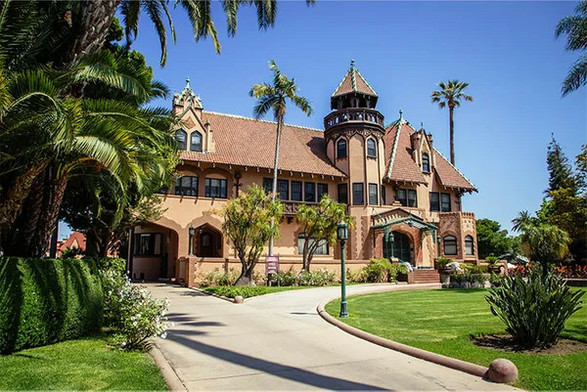 A photo of the late Victorian mansion, fancifully decorated, with turrets and gables. 