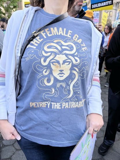 A t-shirt with a drawing of Medusa and the words “The female gaze - petrify the patriarchy”