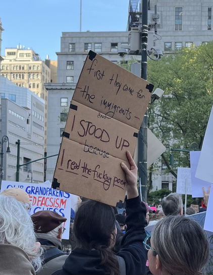 A sign that says “When they came for the immigrants, I STOOD UP because I read the fucking poem!”