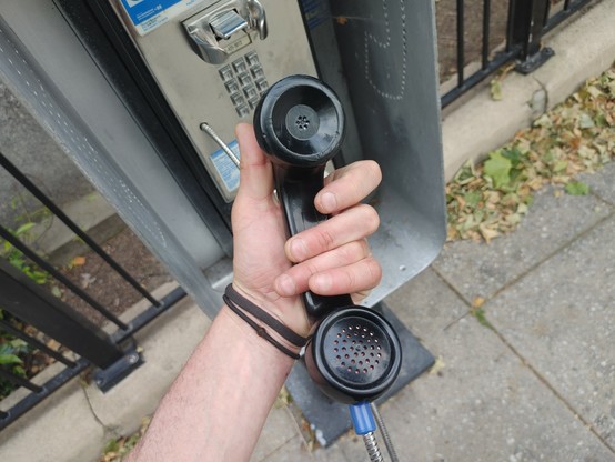 Me holding the cupcakes (handset) to an old pay phone by the bell tower.