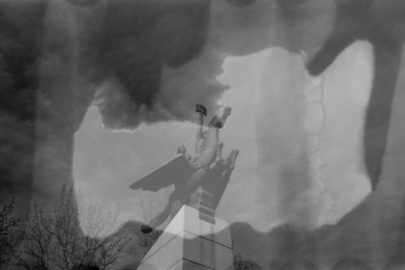 Lucky SHD 400

**English alt text:** A black and white photograph with a double exposure effect, featuring a winged statue holding an object, possibly a hammer or torch, against a cloudy sky. The overlay of clouds and trees creates a surreal and ethereal atmosphere.

**Chinese alt text:** 一张黑白照片，采用双重曝光效果，展示了一座翼状雕像，手持类似锤子或火炬的物品，背景是多云的天空。云层和树木的叠加效果营造出超现实和梦幻的氛围。
