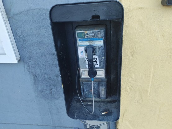 A well beaten pay phone between Santa Cruz Bowl and The Boardwalk