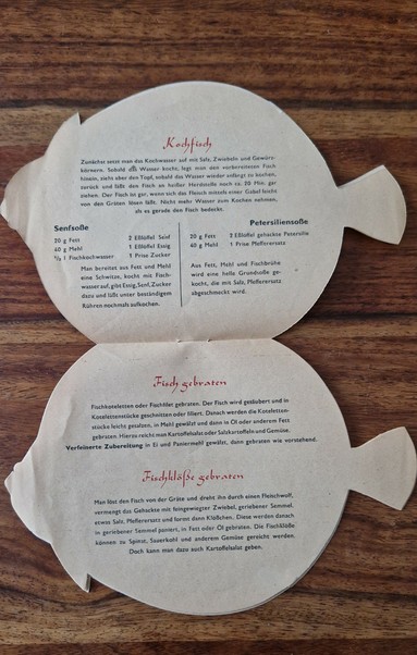 Inside pages of the fish-shaped GDR recipe leaflet, showing instructions for boiled fish and sauces (mustard and parsley), as well as recipes for fried fish and fried fish dumplings. The layout follows the shape of the fish and features concise, utilitarian cooking instructions.