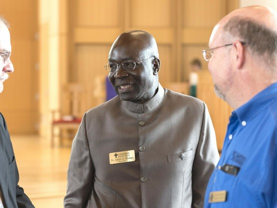 A man in clerical garb and a nametag.