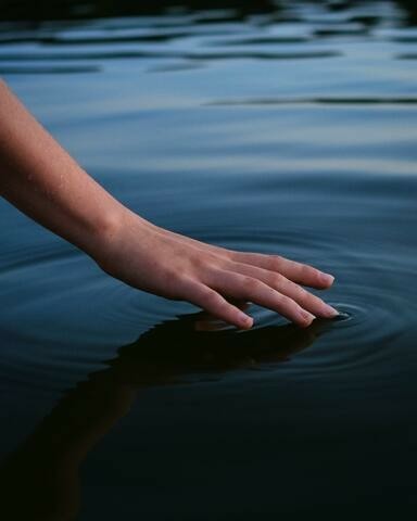 A hand touching water.