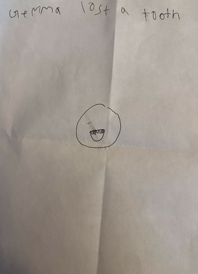 A folded letter which says “Gemma lost a tooth” and has a drawing of a head with an open mouth and a top row of teeth.