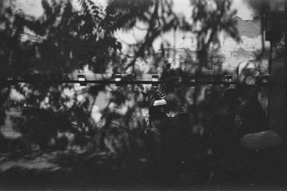 Ilford FP4 @ ISO 64

English Alt Text: A textured wall catches the dappled shadows of tree branches and leaves in black and white. Several electrical meters are mounted in a row, while a scooter is partially visible in the lower right corner. Cracks and wear on the wall add a sense of age and atmosphere.

中文替代文本: 一面老旧墙壁上布满斑驳光影，树枝和叶子的阴影斜洒其上。墙上排列着几个电表，右下角部分可见一辆踏板摩托车。墙体的裂痕与磨损增添了岁月感与画面质感。