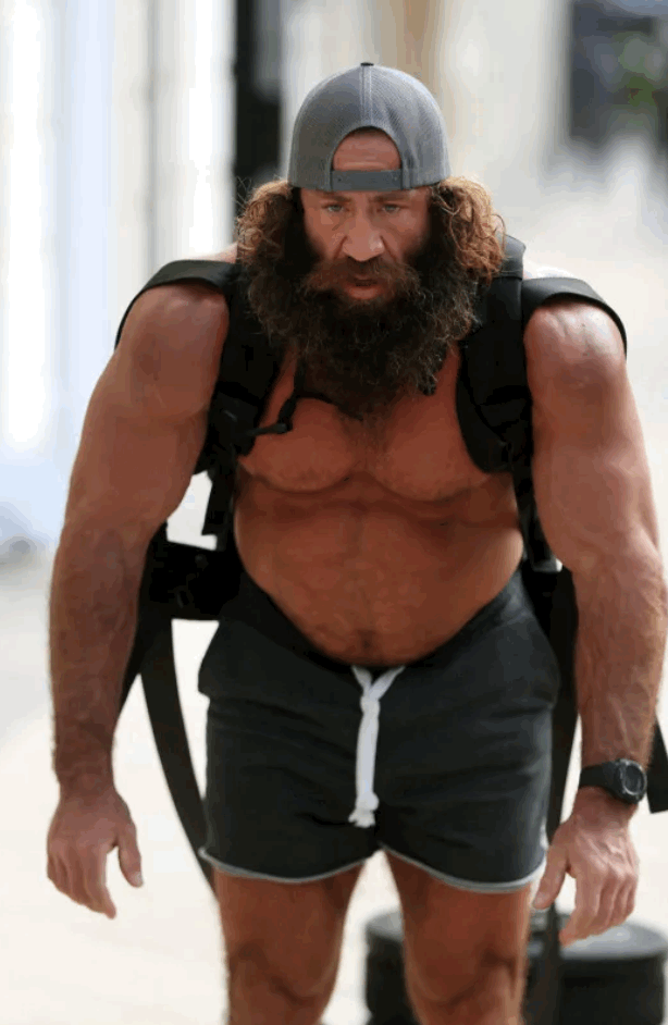 Photo of LiverKing, some weirdo who’s challenged apparently eats a lot of liver. White dude with long dark hair and long beard, wearing gray shorts and some kind of harness thing over his bare shoulders, no shirt. Grotesquely muscular arms and shoulders, maybe a hunched back. Mouth-breather. A gray gimme cap on his head, backwards. Pot belly. Dude’s got issues.