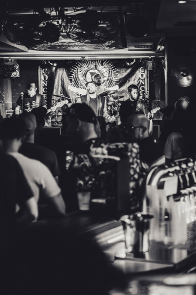 Konzertfoto der Düsseldorfer Punkrock Band Goodbye Grief. Abgebildet sind vier weiße männliche Personen in kurzer Kleidung auf einer Bühne mit Instrumenten. 