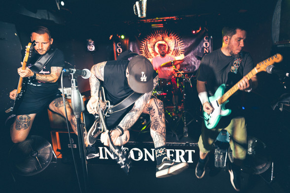 Konzertfoto der Düsseldorfer Punkrock Band Goodbye Grief. Abgebildet sind vier weiße männliche Personen in kurzer Kleidung auf einer Bühne mit Instrumenten. 