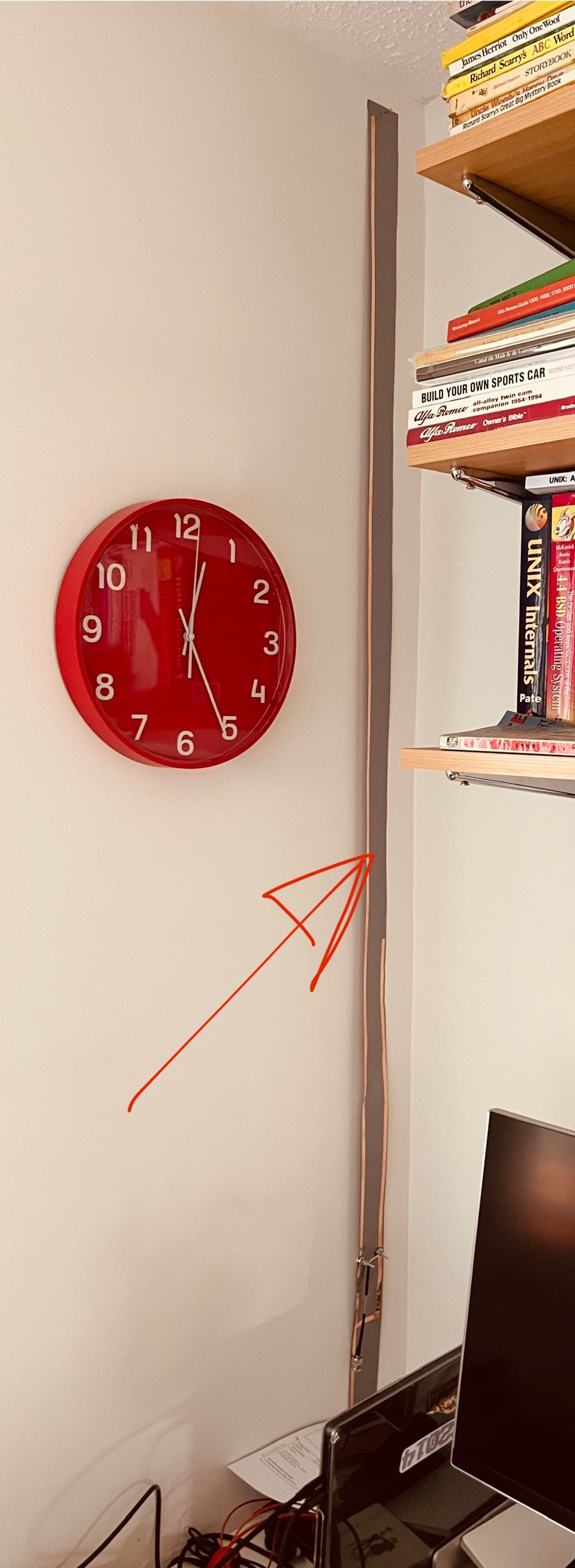 A strip of duct tape hangs in the corner of an office. The tape is actually an antenna.