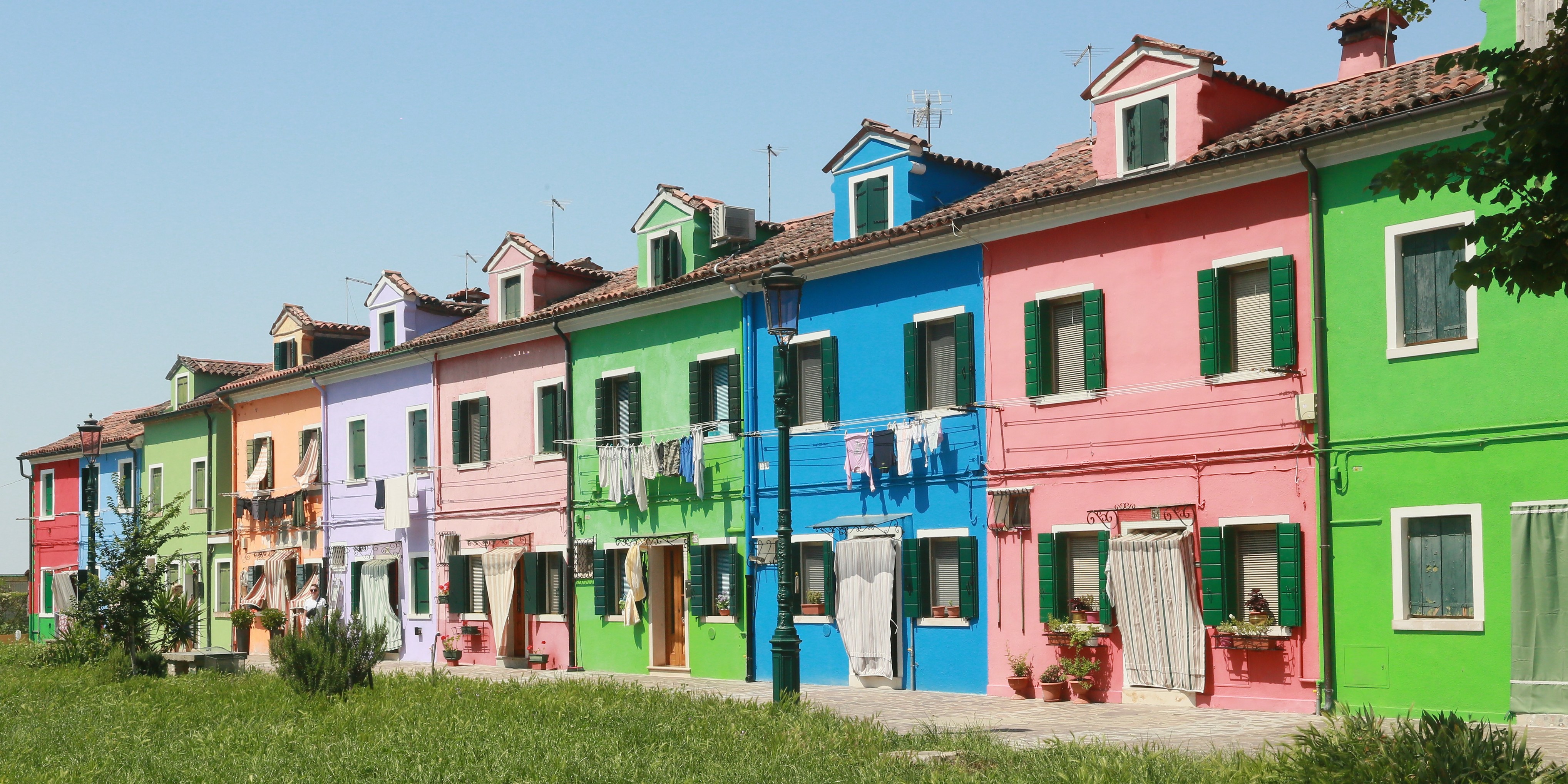 A row of brightly-coloured houses, some of which have laundry hanging outside. A row of brightly-coloured houses, some of which have laundry hanging outside.