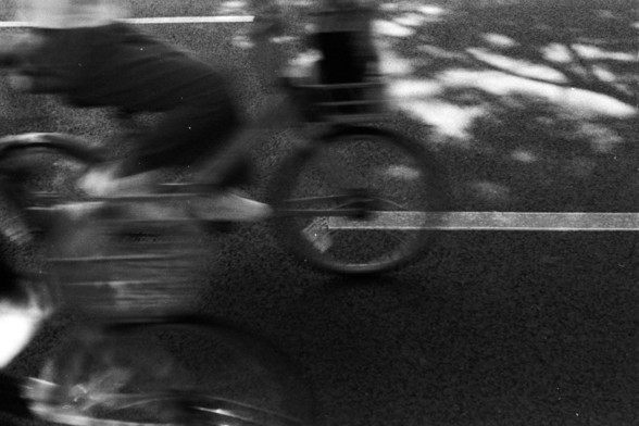 Fujifilm Neopan 100 SS (FF)

**English:**
A black and white photograph capturing the motion blur of a cyclist riding on a road. The cyclist is in motion, creating a dynamic sense of speed and movement. The background is slightly blurred, emphasizing the cyclist's movement.

**Chinese:**
一张黑白照片，捕捉到一位骑自行车的人在道路上骑行时的动态模糊效果。骑行者正在运动中，创造出一种动态的速度和移动感。背景稍微模糊，强调了骑行者的运动。
