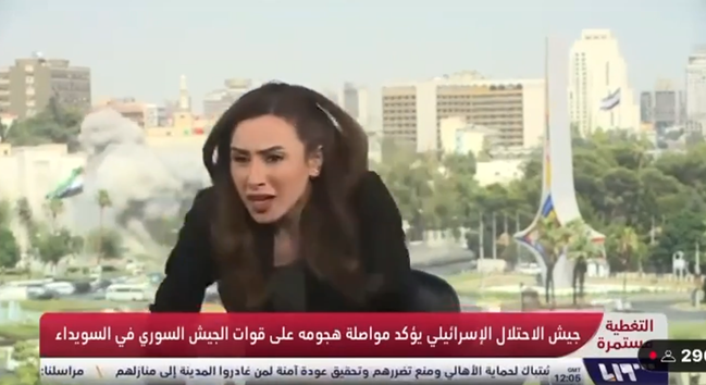 TV host ducking away after a giant explosion occurred, visible in the background and audible on the show.