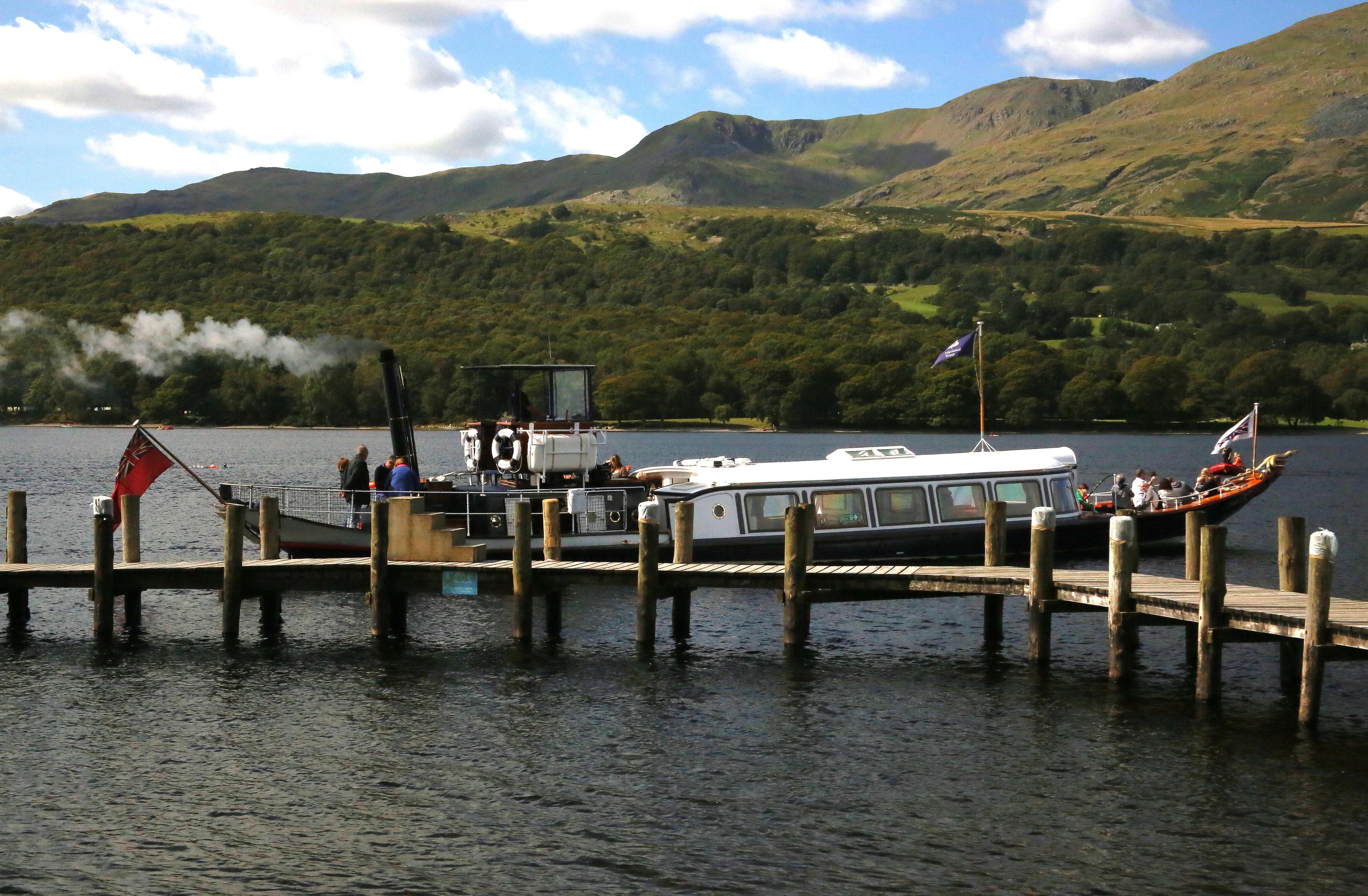 An old steamboat leaves a wooden quay, with low hills in the background. An old steamboat leaves a wooden quay, with low hills in the background.
