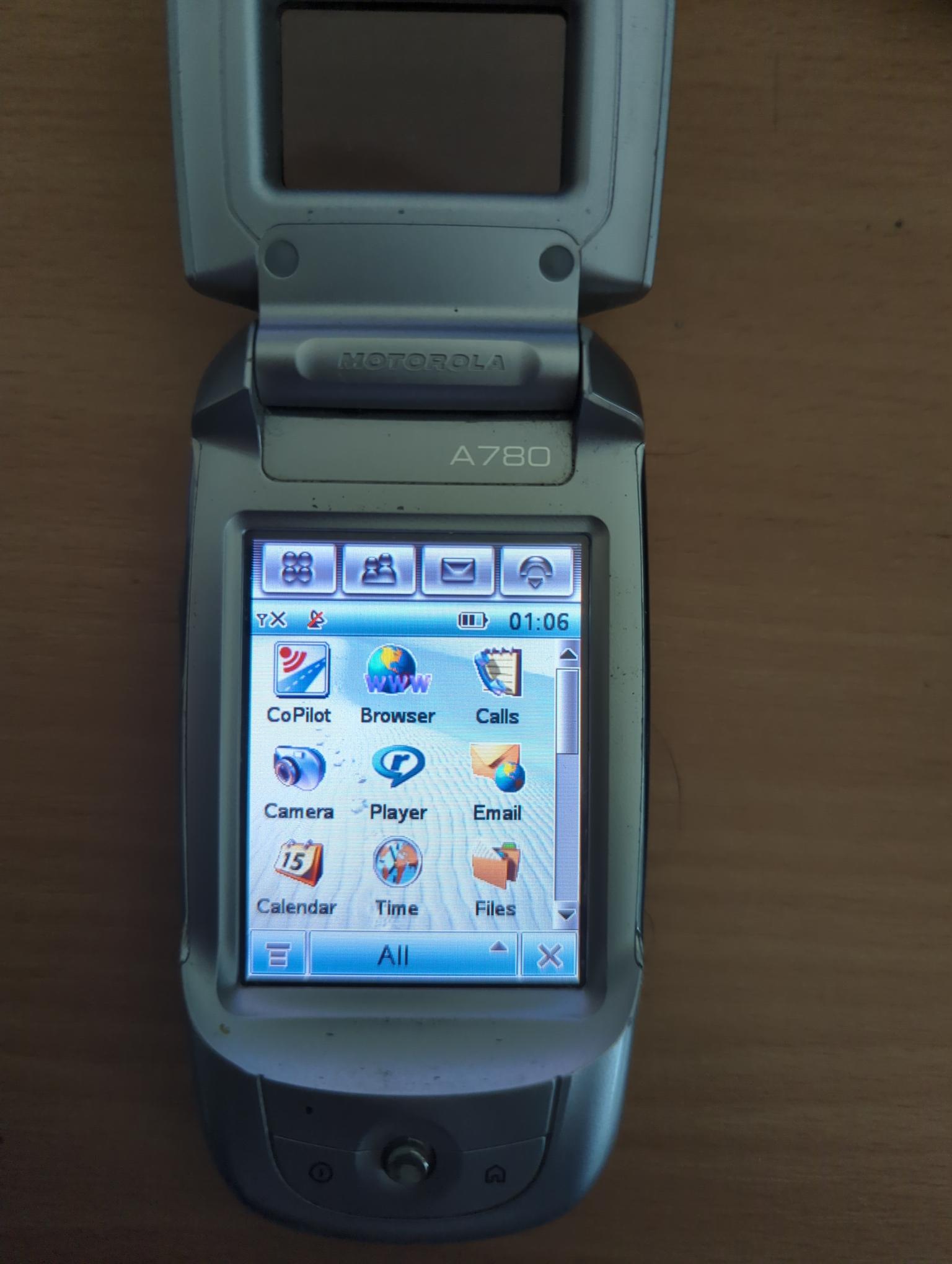 A Motorola A780 (Linux touch phone with a flip) showing its menu, including the CoPilot navigation app