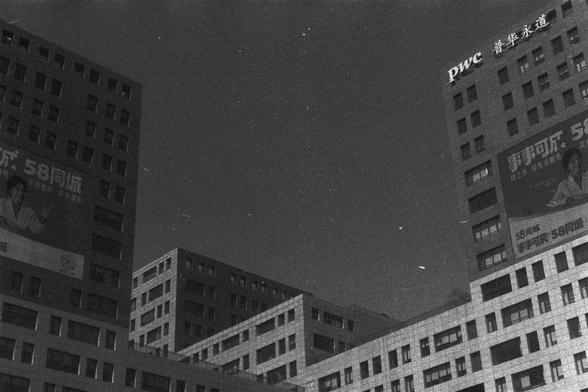 Ilford FP4 Plus 125 (FF)

• English Alt Text: A nighttime cityscape featuring several tall buildings with illuminated windows. Prominent advertisements are visible on the buildings, including “58同城,” “58集团,” and “pwc 普华永道.” The architecture creates a striking urban composition.
• Chinese Alt Text: 夜间城市景观，画面中有几栋高楼，窗户灯光明亮。建筑上可见显眼的广告标语，包括“58同城”、“58集团”和“pwc 普华永道”。整体构图展现了都市建筑的独特美感。