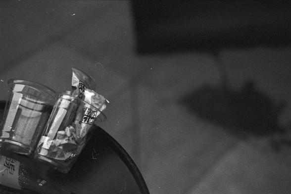 Ilford FP4 Plus 125 (FF)
English Alt Text:
Two plastic cups placed on a dark surface, each containing a packaged snack with East Asian script on the label. The background is softly blurred, and a shadow falls on the right side, creating a cozy, intimate atmosphere.

中文替代文字：
两个塑料杯放在深色表面上，每个杯子里都有一个带有东亚文字标签的包装零食。背景模糊，右侧有阴影，营造出温馨的氛围。