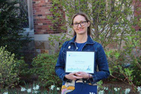 A student holding a certificate.
